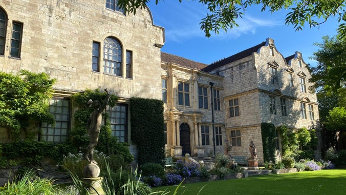 Stone house with a lawn and fountain in the foreground